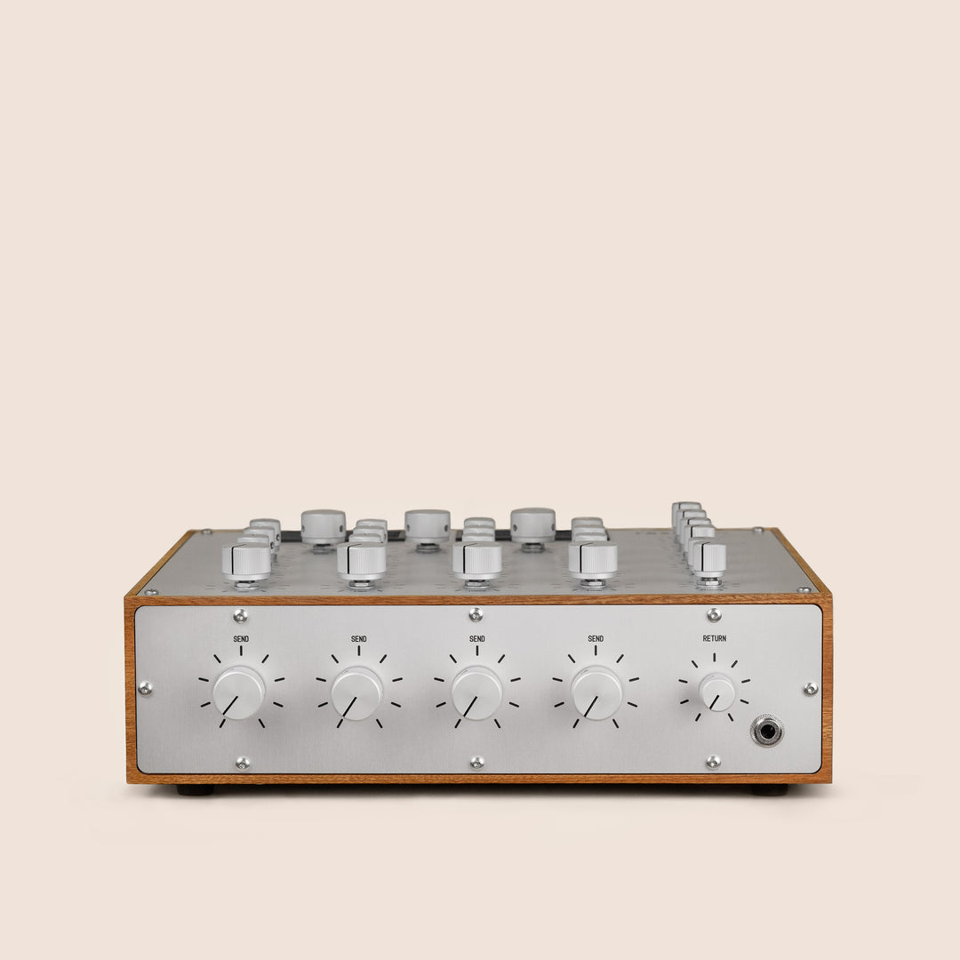 Audio mixer console with knobs and dials on a beige background